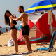 A man applies sunscreen to a woman as they visit the beach during Memorial Day weekend on May 26, 2019 in Asbury Park, New Jersey.